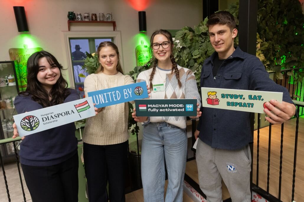 Hungarian Diaspora Scholarship students posing with community-themed signs at the Welcome Home event in Hungary.